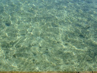 Clear transparent waters of a beach with the bottom from the surface
