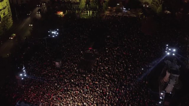 Aerial shot above an open-air stage concert at night in the city