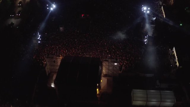 Aerial shot above an open-air stage concert at night in the city