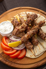 Barbecue. Barbecue grill with meat, closeup. Kebab with juicy meat. Barbecue skewers with juicy meat on plate. 