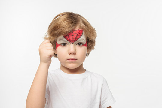 Cute, Confident Boy With Spiderman Mask Painted On Face Showing Fist At Camera Isolated On White