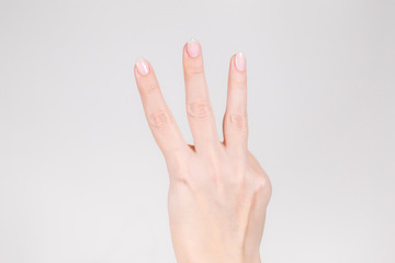 Closeup view photography of white female hand with raised three fingers up.