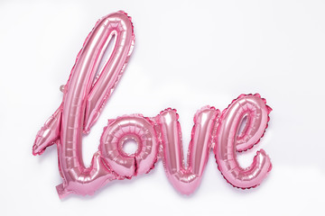 Pink balloons in the form of word Love on white background. Valentines day celebration.
