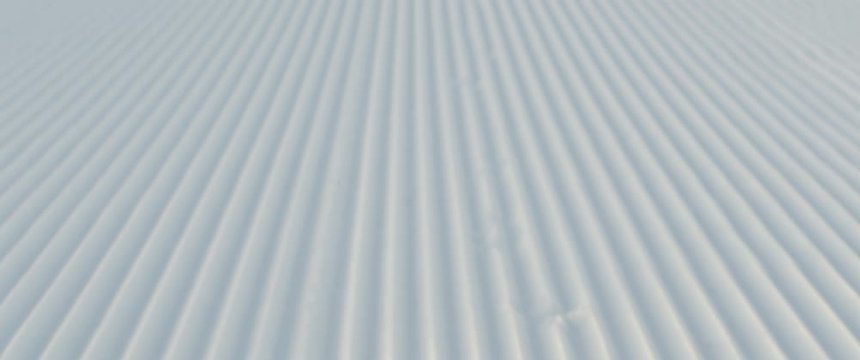 CU DOLLY SHOT of fresh groomed perfect corduruy slope on a skiing resort. 4K UHD RAW graded footage