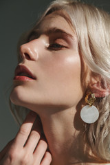 Fashion beauty portrait of young beautiful woman wearing earrings.