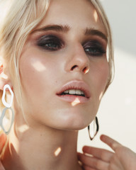 Fashion beauty portrait of young beautiful woman wearing earrings.