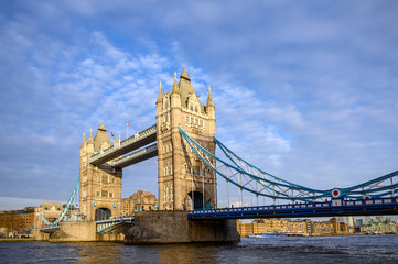 Fototapeta na wymiar Tower Bridge in the City of London, UK. Tower Bridge crosses the River Thames and is one of the most famous tourist sights in London. Wide angle view of Tower Bridge in late afternoon light.