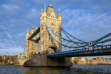Fototapeta na wymiar Tower Bridge in the City of London, UK. Tower Bridge crosses the River Thames and is one of the most famous tourist sights in London. Landscape view of Tower Bridge in late afternoon light.