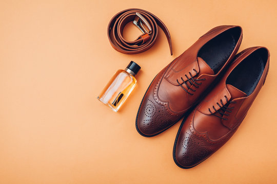 Oxford male brogues shoes with accessories. Men's fashion. Classical brown leather footwear with belt and perfume.