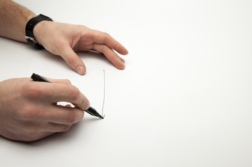 Black marker in the hands of a man. Writes on a blank sheet of paper. White background