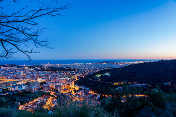 Skyline horizonte en atardecer con color azul y calles iluminadas naranjas desde mirador del mirador del tibidabo