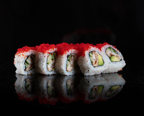 Japanese Sushi isolated on black background. Reflection in a mirror surface. Close up. Studio photo.