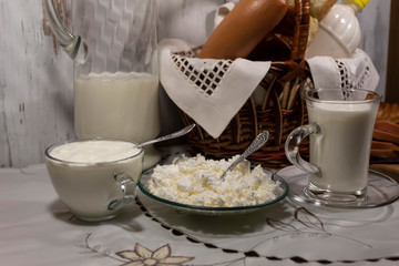 In the foreground there is a cup of milk, in a bowl of cottage cheese and in a cup of sour cream....