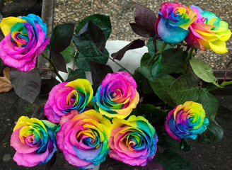 Fototapeta na wymiar Multicolored roses in the white vase.Selling flowers on the street
