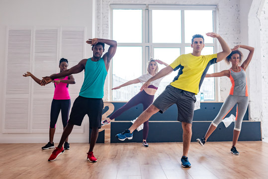 Multicultural dancers performing zumba in dance studio