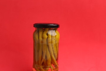 chili peppers in glass canned jar with vinegar