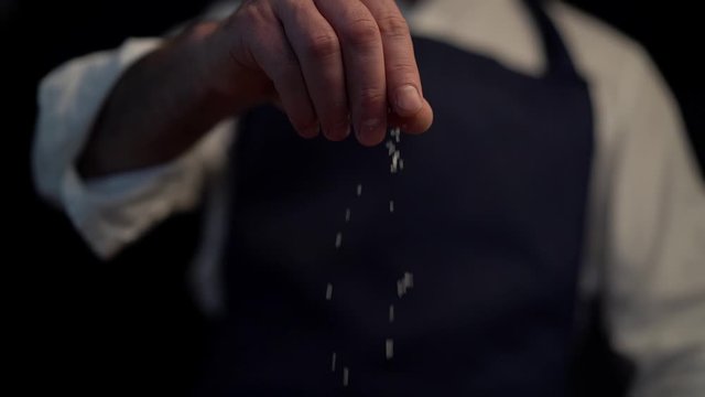 Chef adds salt to the dish, cooking in slow motion
