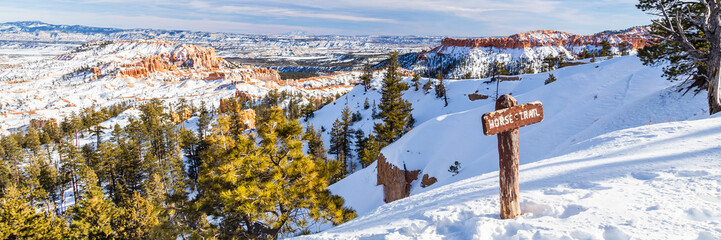 Horse trail sign post in Bryce Canyon National Park in Winter covered with snow