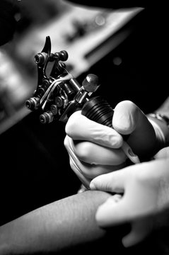 Cropped Image Of Tattoo Artist Doing Tattoo On Arm