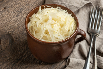 Fermented cabbage on a table in a brown pot