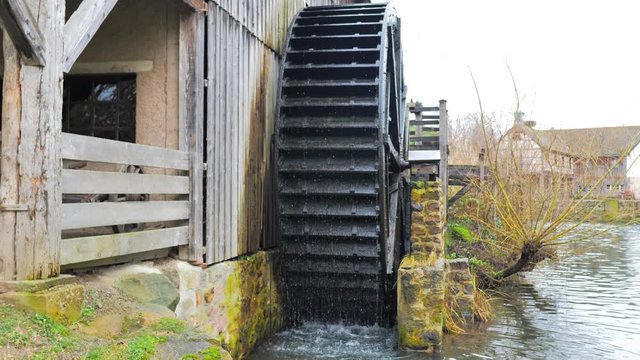 Rueda con aspas de madera de viejo molino de agua girando en cascada