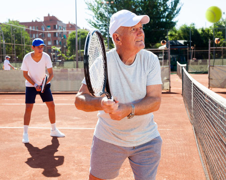 grandfather and grandson playing tennis court