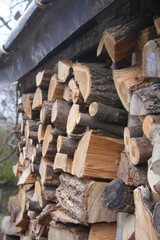 Large log store filled with firewood in the garden ready for winter season. Woodpile on outdoors