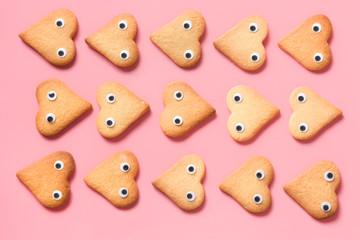 Border of homemade heart shaped cookies on pink. Flat lay.