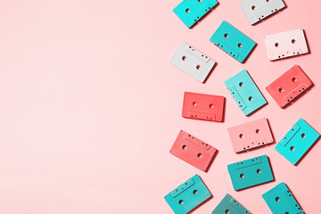 Painted audio cassettes in bright colors and blue earphones on pastel background, copy space, top view. Retro musical background. Retro audio tape cassettes, 80s background, pastel retro flat lay