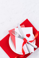 Fototapeta premium Valentine's Day, Mother's Day, holiday dating meal, banquet design concept - White plate and red ribbon on marble background, top view, flat lay.