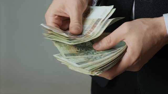 Men's hands quickly count banknotes. Businessman counts banknotes of polish zloty in hands. PLN