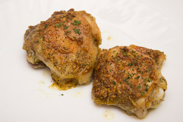 Freshly baked chicken thighs in oven from clouse up on white background