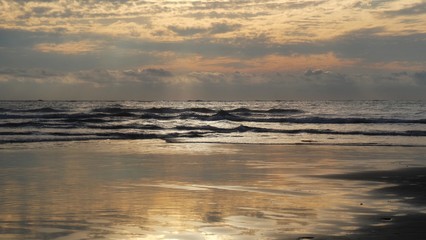 sunset over the sea, reflecting on beach