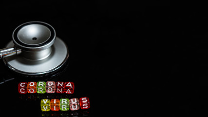 Colorful text "Corona virus" and   Medical stethoscope  put on  Black background. corona virus Concept.