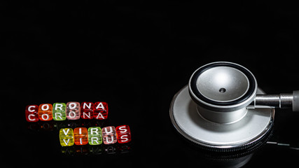Colorful text "Corona virus" and   Medical stethoscope  put on  Black background. corona virus Concept.