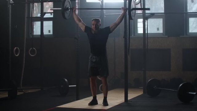 Male bodybuilder doing exercise with heavy weight bar. Full length of fitness man practicing deadlift at health club