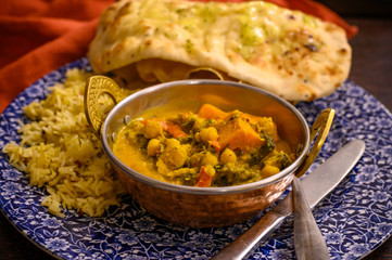 Mangalorean style roasted cauliflower and spinach curry with basmati rice and garlic naan bread, tasty vegetarian food