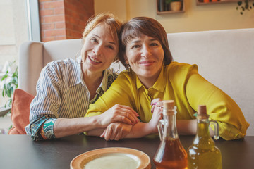 Two happy mature women in restaurant