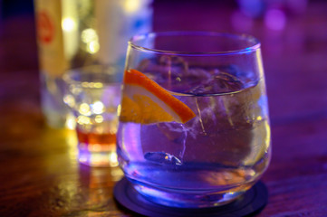 Glass of gin with tonic water, orange and ice
