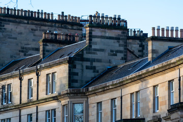 Obraz premium Roofs and chimneys in New Town part of Edinburgh city, capital of Scotland, in sunny winter morning