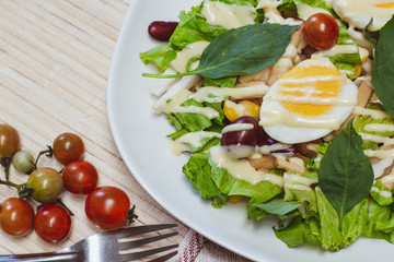 Vegetable salad, boiled eggs, tomatoes, tableware