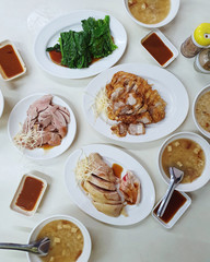 A typical Chinese breakfast of market food /Bowl of Congee,Chopped boiled chicken,Crispy Roasted Pork,Roasted Duck,BBQ Pork and Noodle.