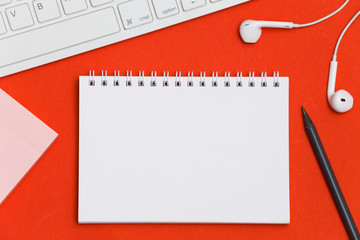 Creative flat lay photo of workspace desk with copy space. Top view office desk with notepad, red background