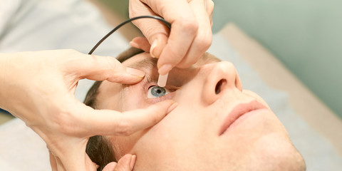 ophthalmologist doctor in exam optician laboratory with male patient. Men eye care medical diagnostic. Eyelid treatment