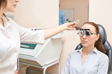 ophthalmologist doctor in exam optician laboratory with female patient. Eye care medical diagnostic. Eyelid treatment