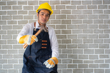 Home mechanic man fix brick wall in modern room with hammer