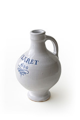 A 17th Century white glazed stoneware bottle with the word Claret and the date painted onto it.