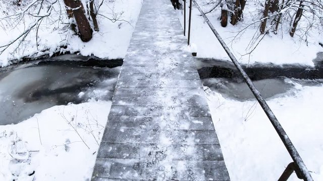 Pedestrian bridge over river. Winter snow landscape. Stock vedeo on go