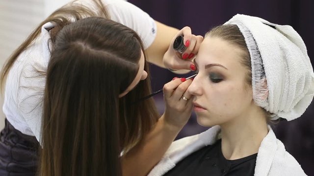 Make-up artist does makeup to young girl