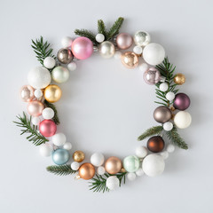 Natural Christmas wreath with green pine tree branches and ball decoration. Creative copy space layout. Flat lay background.